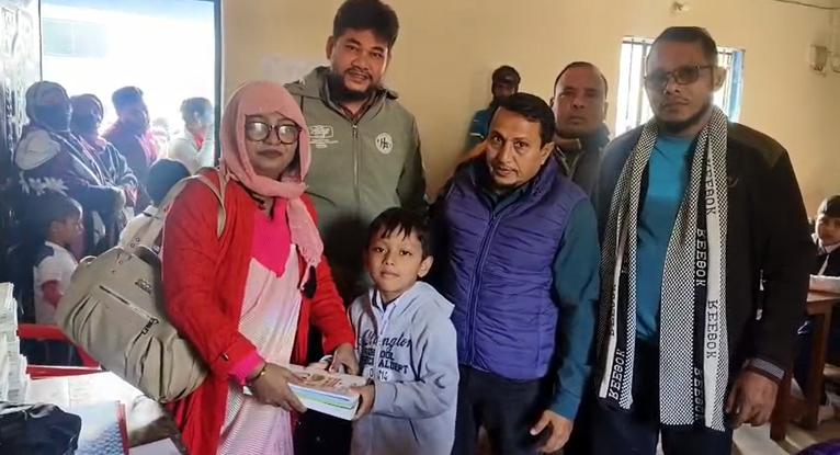 বই বিতরণ করছেন কলাপাড়া মঙ্গলসুখ মডেল সরকারি প্রাথমিক বিদ্যালয়ের প্রধান শিক্ষক নাজমুস সাকিব খান কনা